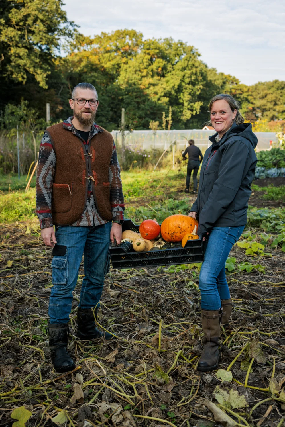 Johannes en Marieke in de tuin met een kist pompoenen